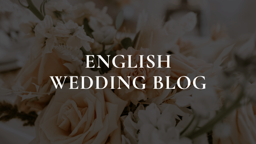 A sophisticated display of creamy white roses and delicate flowers sets a romantic backdrop for the bold text 'ENGLISH WEDDING BLOG