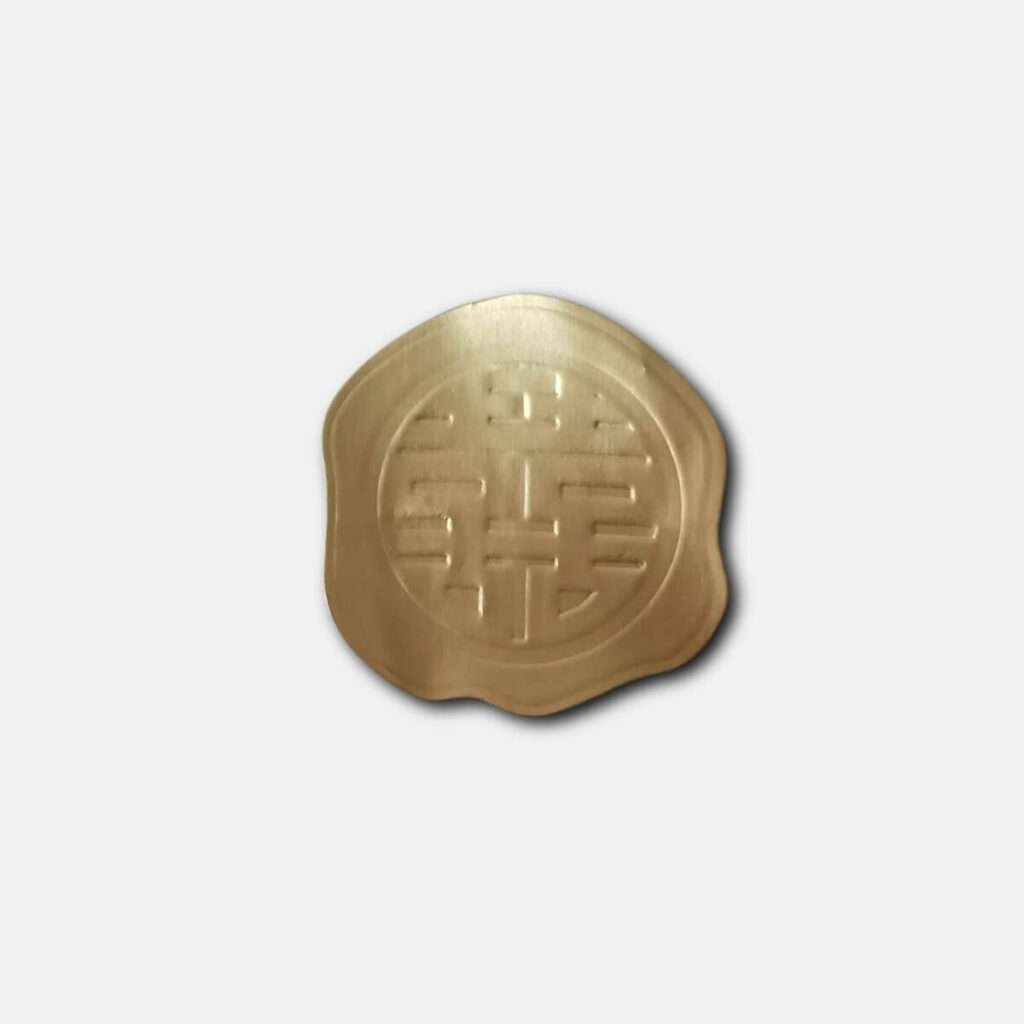 Circular gold wax seal stamped with the traditional Chinese 'Double Happiness' symbol, commonly used for wedding occasions.